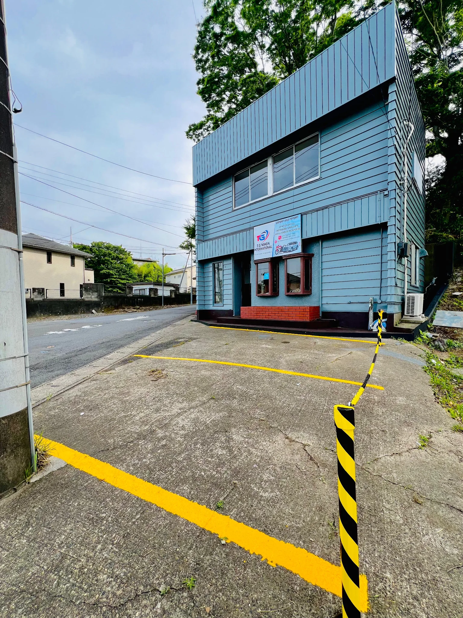 Front view of TG Nihon International office building and customer parking area